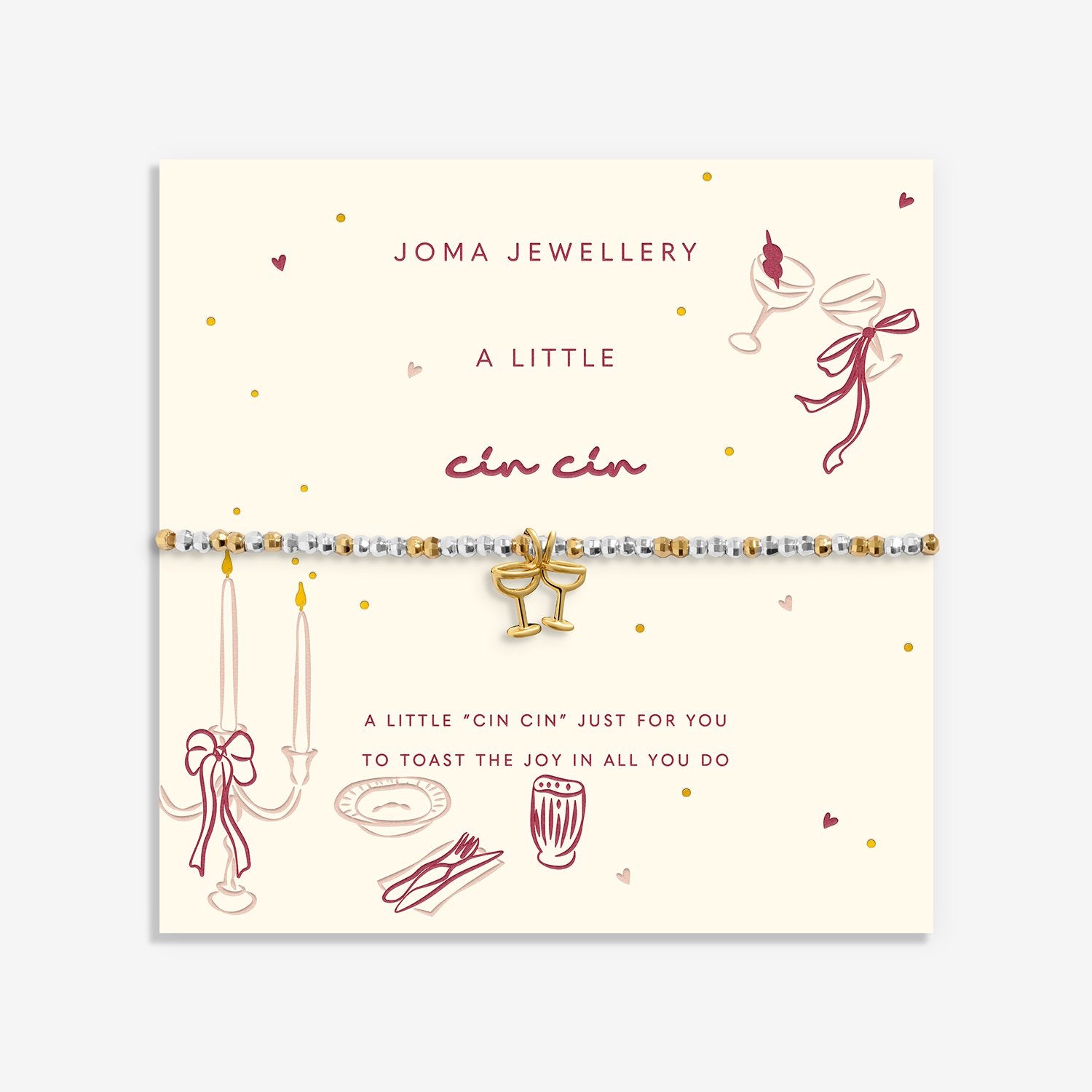 A delicate beaded Joma Jewellery bracelet with gold coloured glasses charm, presented on a cream-coloured card.