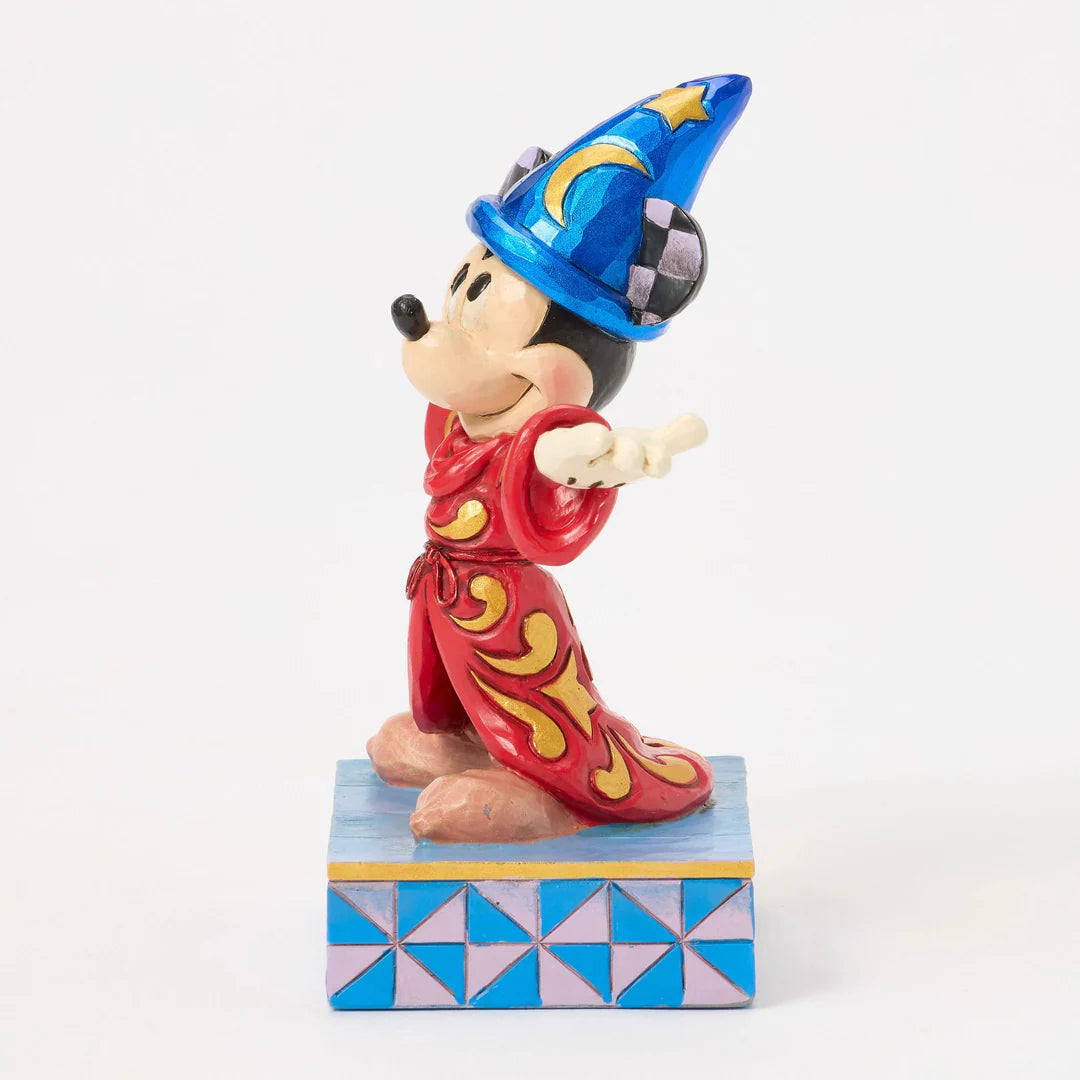 Mickey Mouse figurine in a wizard costume on a white background