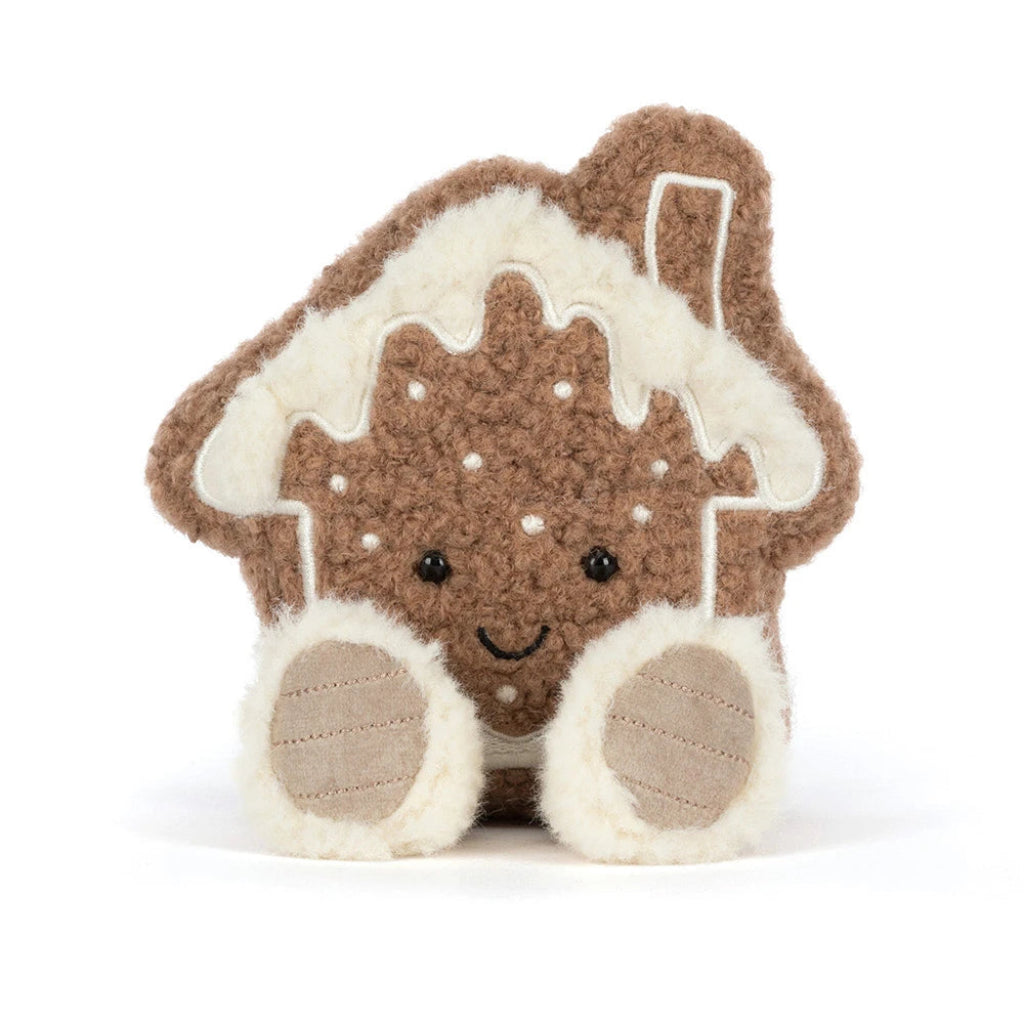 Jellycat Molasi Cookie gingerbread house plush toy with a brown textured body, cream-colored icing, embroidered facial features, and soft cream paws, photographed on a clean white background.