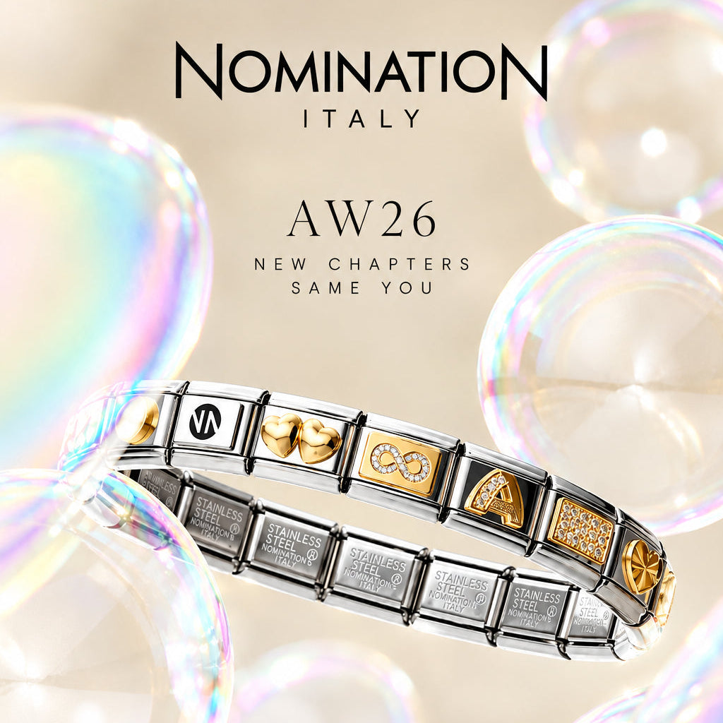 A Nomination Italy charm bracelet with silver and gold links, featuring various engraved and symbol charms, displayed against a soft beige background with floating iridescent soap bubbles.