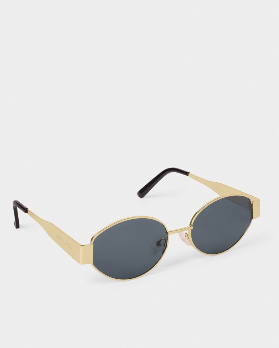 katie loxton Gold-framed sunglasses with black lenses on a white background