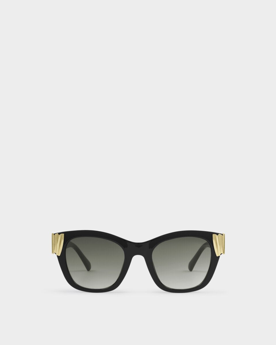 katie loxton seychelles Black sunglasses with gold accents on a white background