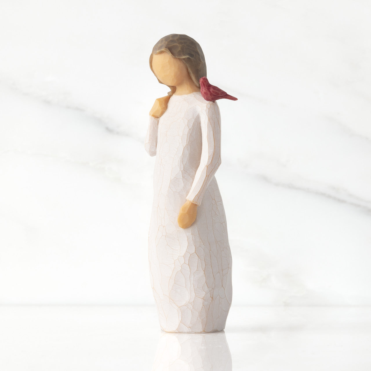 willow tree messenger Figurine of a woman with a red bird on a white background