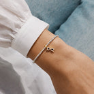 Joma Jewellery Silver beaded bracelet with a gold and black sunglasses pendant on a persons wrist