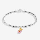 A Joma Jewellery 'A Little Sweet Like Chocolate' bracelet  which features a silver-toned beaded chain with a pink and red heart on a chocolate bar charm.