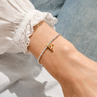 Joma Jewellery image featuring a small pizza slice on a silver beaded bracelet on a persons wrist