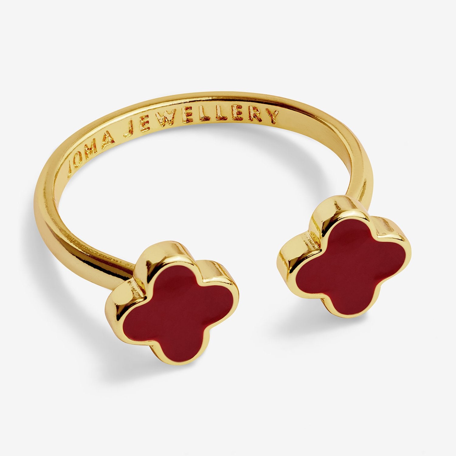 Gold ring with red clover-shaped stones on a white background