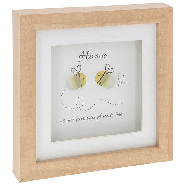 Framed  artwork with two bee-shaped pebbles and text 'Home is our favourite place to bee' on a white background.