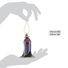 Decorative ornament of the Evil Queen in a purple gown held by a hand with measurements displayed.