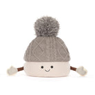 Jellycat amuseables pomilly hat with a gray cable-knit top, a cream ribbed bottom, a gray pom-pom, and small fabric hands and feet, shown on a white background.