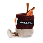 Jellycat amuseables spiced drink with a smiling face, wearing orange goggles and brown boots, on a solid white background.
