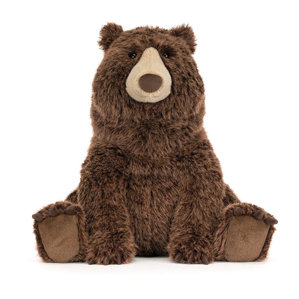 Bizzlestomp is a brown plush stuffed bear by jellycat. Sitting upright against a plain white background.