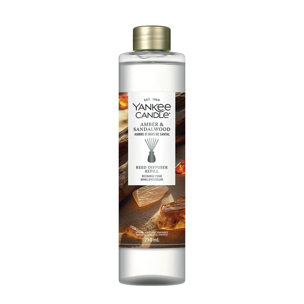 A Yankee Candle Amber & Sandalwood reed diffuser refill bottle with a gold cap, shown on a plain white background.