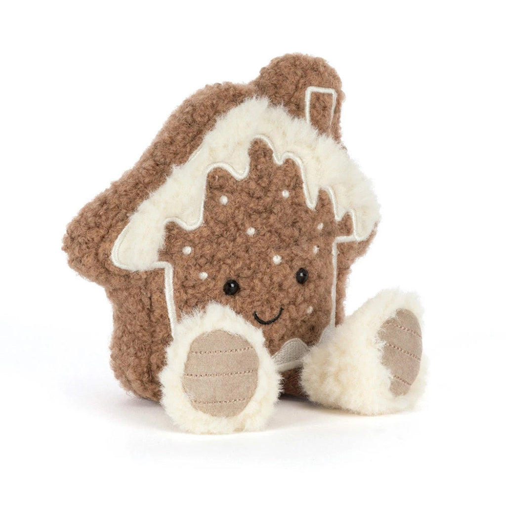 Amuseables Molasi Cookie plush  gingerbread house toy with a brown curly-textured body, cream-colored icing details, embroidered facial features, and two small plush feet, photographed on a clean white background.