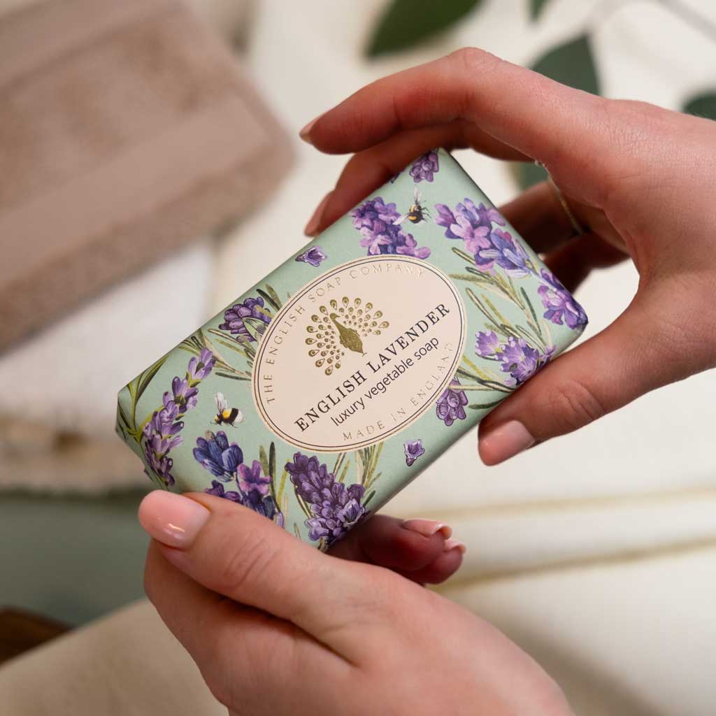 Hand holding a bar of soap with lavender design and 'English Lavender' branding.