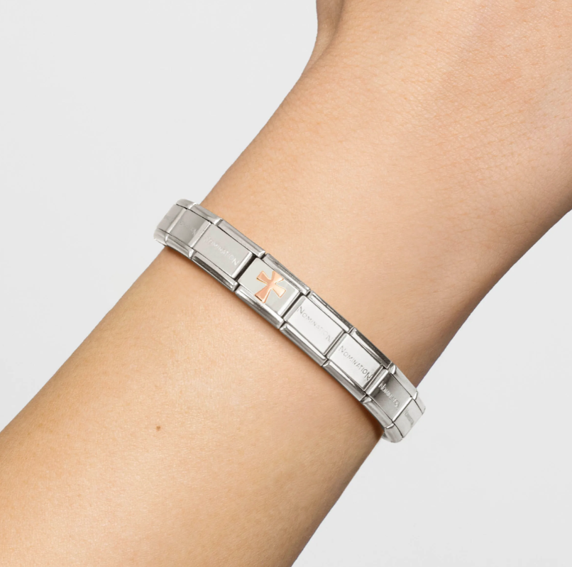 Rose Gold nomination Italy cross charm, attached to the composable bracelet on a female's wrist.