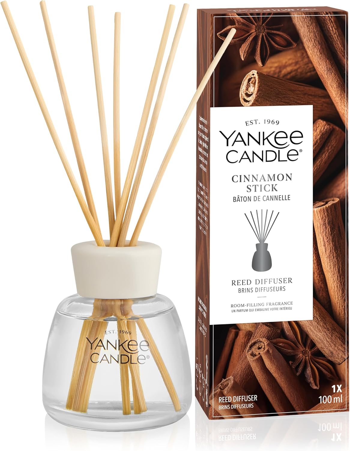 Yankee Candle Cinnamon Stick reed diffuser set with a clear glass bottle, beige reeds, a white cap, and the branded retail box on a white background.