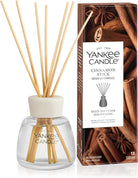 Yankee Candle Cinnamon Stick reed diffuser set with a clear glass bottle, beige reeds, a white cap, and the branded retail box on a white background.