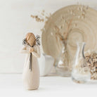 willow tree friendship figurine holding a floral arrangement against a neutral background