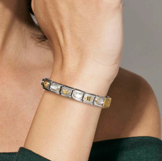 Nomination Italy showing a close-up of a person's arm wearing a bracelet with numerous themed composable charms
