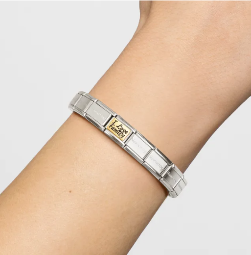 Nomination Italy Silver bracelet with a gold and enamel charm with the sentiment I love family on a wrist against a light gray background.
