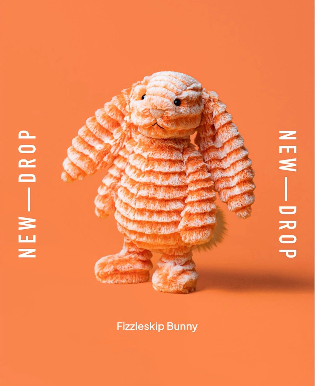 An orange Fizzleskip jellycat bunny with textured, layered fur stands centered on a solid orange background. White vertical text on both sides reads 'NEW - DROP', and white text at the bottom reads 'Fizzleskip Bunny'.