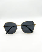 Gold-framed sunglasses with black lenses on a white background
