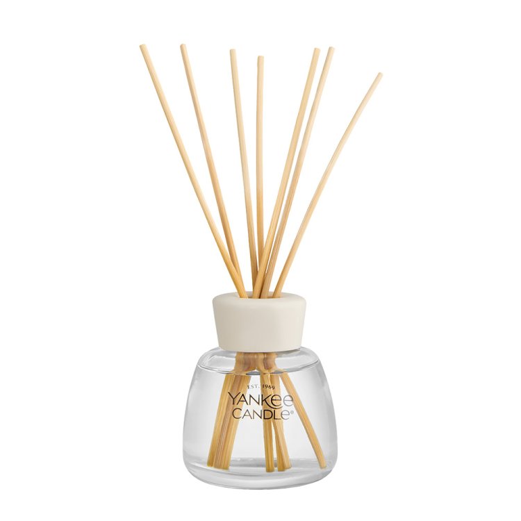 Yankee Candle reed diffuser with a clear glass bottle, natural wood reeds, and a cream-colored cap on a white background.