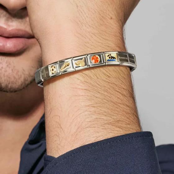 Close-up of a person's wrist wearing a Nomination Italy sterling silver and stainless steel bracelet with various symbols.