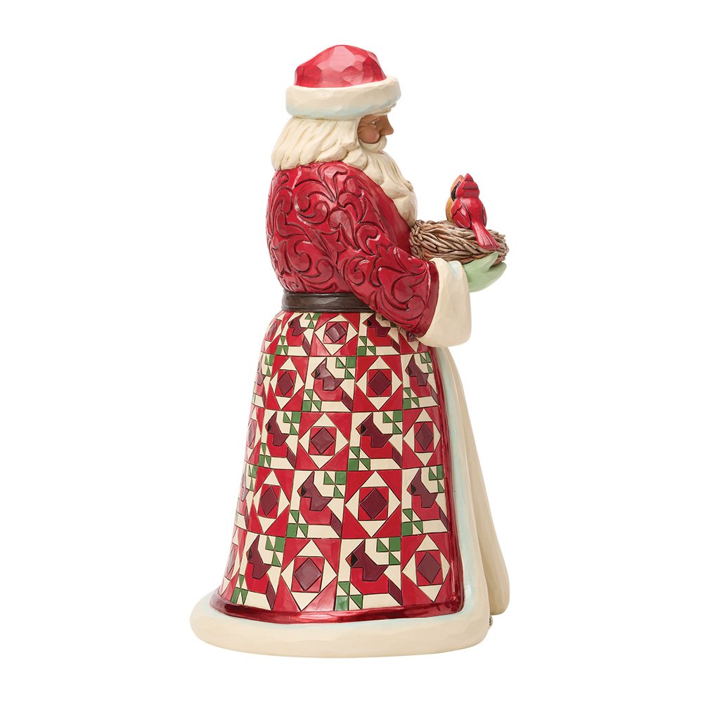A Santa Claus figurine shown from the side, wearing a red and white patterned robe with a red Santa hat and holding a red bird in a nest, on a plain white background.