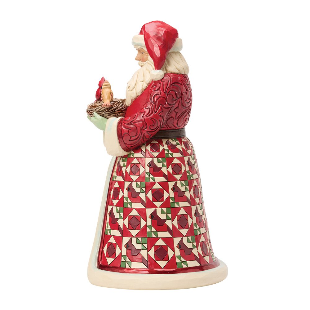 Decorative Santa figurine in a red outfit with a patterned skirt, holding a basket with two birds setting inside.