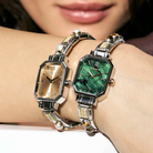 Two women's metal Nomination Composable bracelets with octagonal rectangular watches, one featuring a gold dial and the other a green marbled dial, shown worn on a woman's wrist.