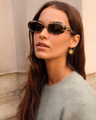 Woman wearing sunglasses with a neutral background