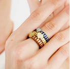 Stack of nomination Italy extension collection gold plated and silver rings. On a finger against a neutral background showcasing the product 