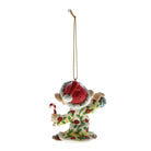 A ceramic Christmas ornament depicting a gnome in a red Santa hat and green holiday pajamas with red berry patterns, holding a candy cane, suspended by a gold string on a white background.