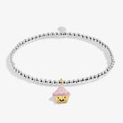 A silver-plated beaded stretch bracelet featuring a cute gold and pink cupcake charm with a smiling face, set against a clean white background.