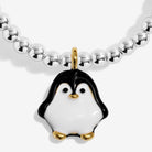 A close-up of a beaded silver-plated bracelet featuring a penguin charm. The bracelet has a strand of polished silver-colored round beads and a central penguin charm with a glossy white and black enamel body, accented by gold-tone details on the beak, feet, and top loop.