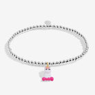 A silver-plated beaded stretch bracelet featuring a small white unicorn charm with a pink bow and gold horn, displayed on a clean white background.