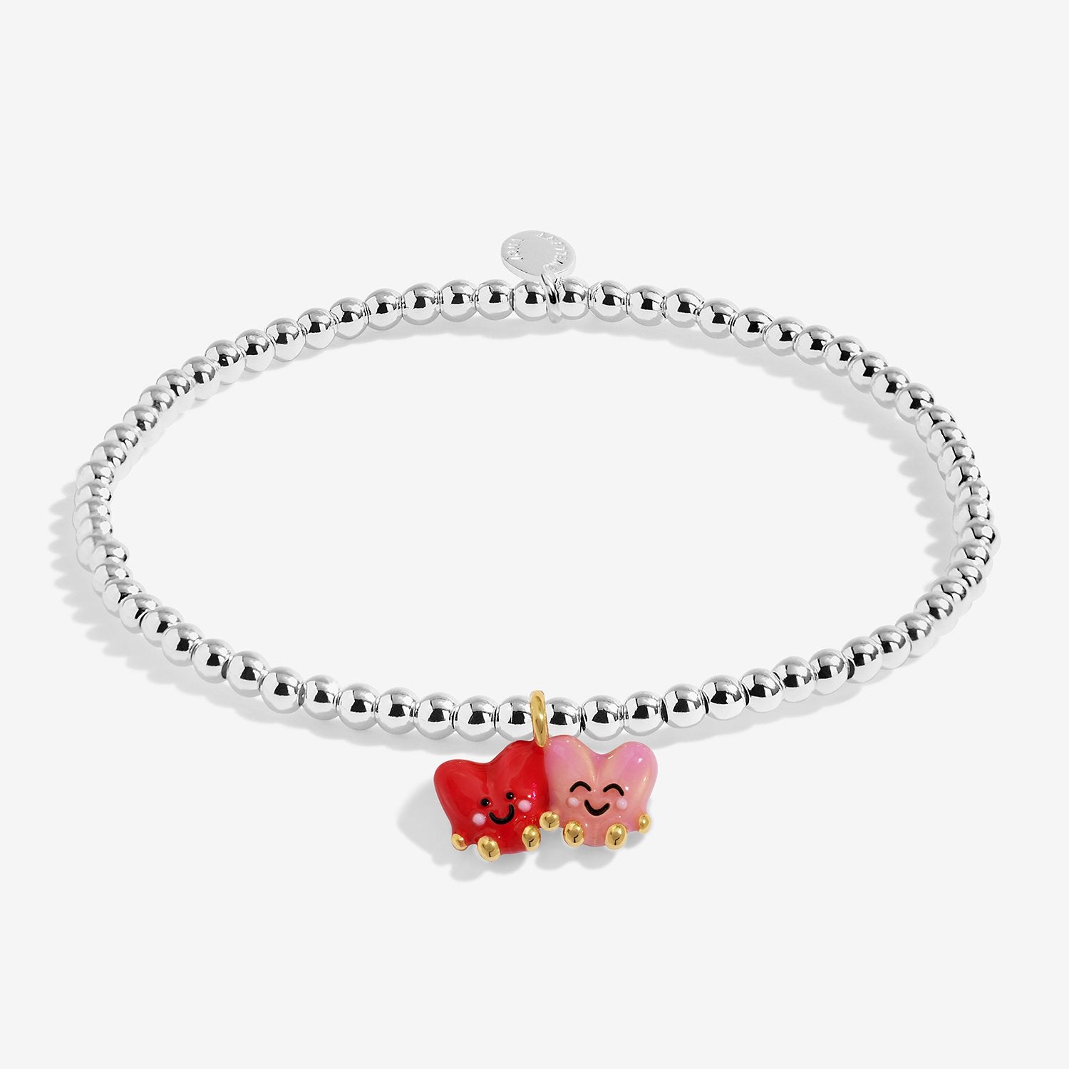 A silver-plated beaded bracelet featuring two small enamel Heart charms in red and pink, with gold-tone accents, shown on a light gray background.