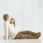 willow tree figures of a father  and his daughter sitting on the floor against a white wall.