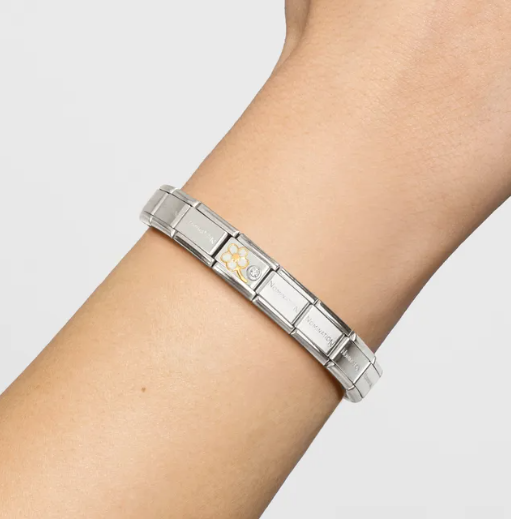 Image showing Nomination Italy composable bracelet with gold forget me not charm on a wrist with a neutral background