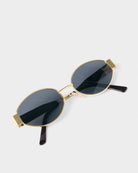 katie loxton Gold-framed sunglasses with black lenses on a white background