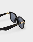 Black Katie Loxton Manhattan sunglasses with gold accents on a white background