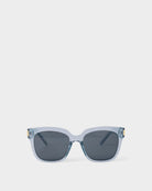 katie loxton roma Sunglasses with a clear frame and dark lenses on a white background