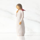 willow tree messenger Figurine of a woman with a red bird on a white background