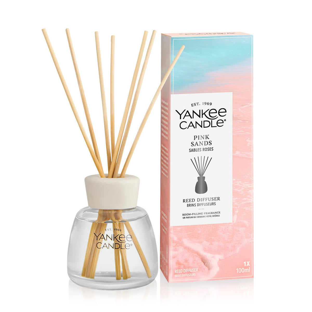 Yankee Candle Pink Sands reed diffuser bottle with natural wood reeds and its retail box on a white background.