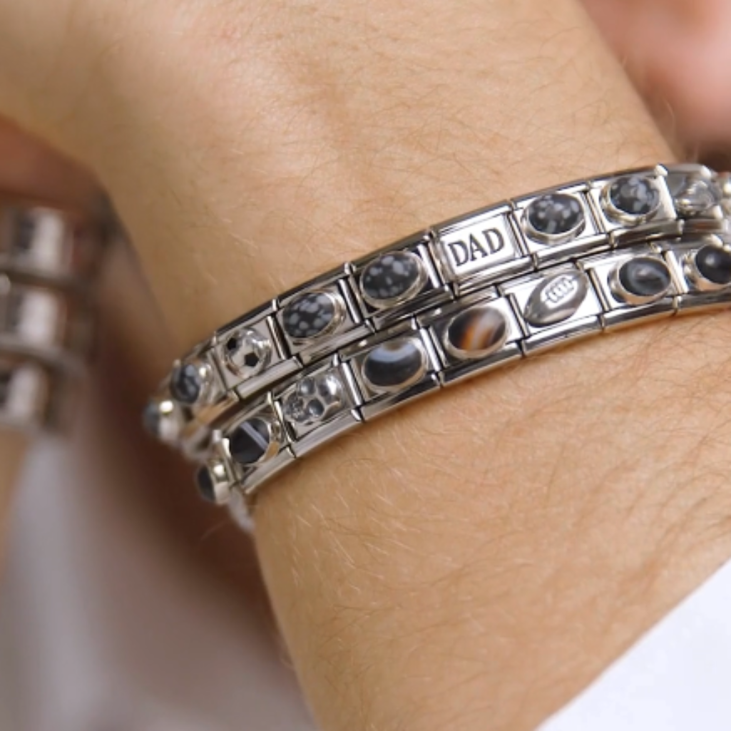 Image showing a person wearing multiple Nomination Italy Composable bracelets with various charms on a wrist