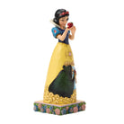Snow White figurine holding an apple on a white background