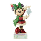 Minnie Mouse figurine in festive outfit with green bow and red dress on a white background