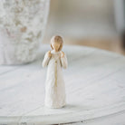 willow tree truly golden figurine of a woman in a white dress on a marble surface